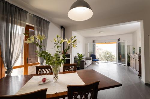 a dining room with a table and a vase of flowers at A casa di nonna in Laiatico