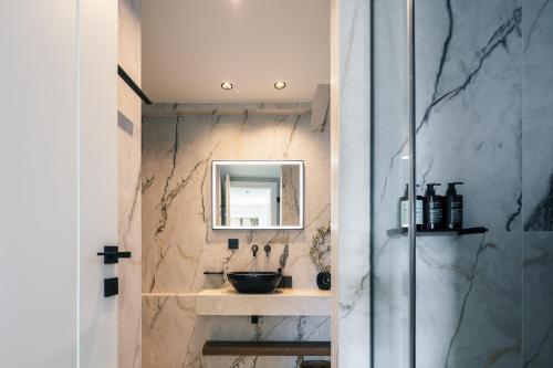 un baño con lavabo y espejo en RIRIKA Beach Living, New Feel-at-Home Luxury Apartments, en Plakias