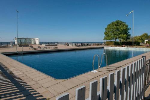 a large swimming pool next to a fence at Visby Snäck Lägenheter, Havsutsikt in Visby