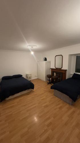 Huge Family Room Clontarf House-4 في دبلن: غرفة نوم بسريرين وارضية خشبية