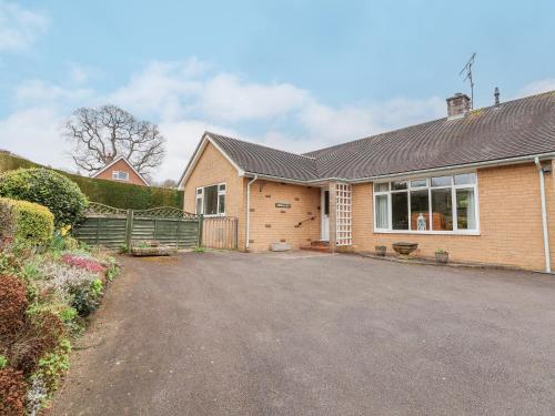 a brick house with a driveway in front of it at The Highlands in Church Stretton