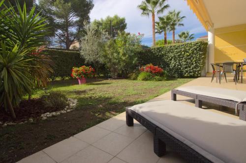 d'une terrasse avec une table et des chaises ainsi que d'un jardin. dans l'établissement Golfe Juan - 4 People - Swimming Pool - Private Parking, à Vallauris