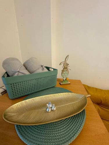 une plaque d'or sur une table avec un panier vert dans l'établissement Calvin Apartment 9, à Ohrid