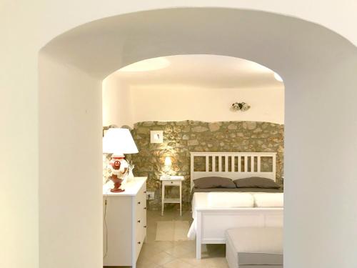 una camera con letto e parete in pietra di Circeii a San Felice Circeo