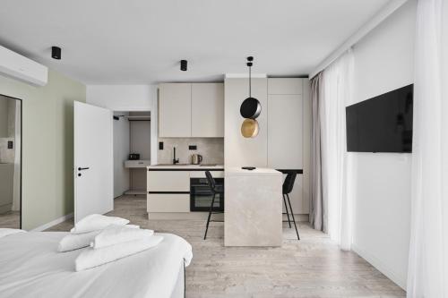 a white room with a bed and a kitchen at Hotel Collect & Residence in Budapest
