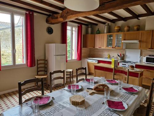une cuisine avec une table et des chaises dans une cuisine dans l'établissement Maison Rouge, à Montagne