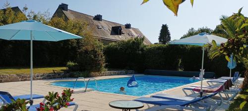une piscine avec des chaises et des parasols et une personne pour la baignade dans l'établissement Keranmeriet B near Pont Aven, Concarneau, beaches 15km, à Melgven