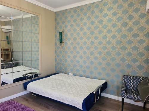 Dormitorio pequeño con cama y espejo en French Villa Provance en Almaty