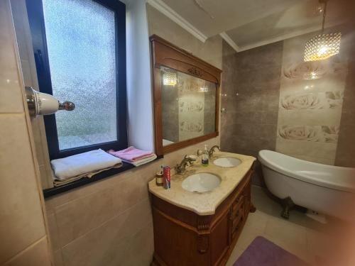 baño con lavabo, bañera y ventana en French Villa Provance en Almaty