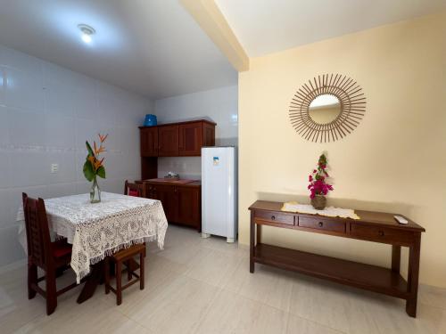 a kitchen with a table and a mirror on the wall at Pousada Berro do Jeguy in Pipa