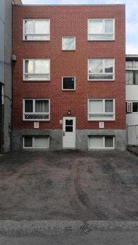 an empty parking lot in front of a brick building at Wonderful Studio in Little Italy with full bath by Den Stays in Montréal