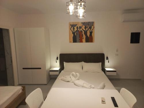 a bedroom with a large white bed with two chairs at Private Villa Aras 2 - Luxury & Elegance Apartments in Vlorë