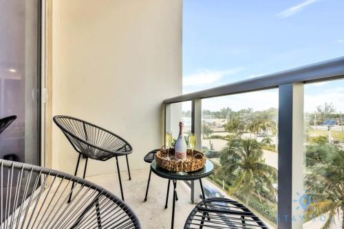 a balcony with chairs and a table with a bottle of wine at Costa Hollywood - Worth Traveling - Rooftop Pool- Gym in Hollywood