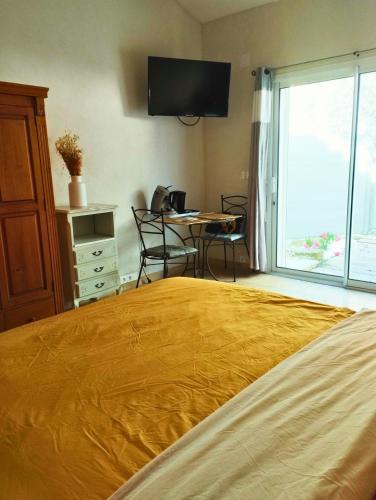 une chambre avec un lit, une table et une télévision dans l'établissement Studio en plein coeur du village, à Beaumes-de-Venise