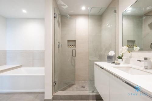 a white bathroom with a shower and two sinks and a tub at Rooftop Pool - Hot Tub - Hollywood Beach Boardwalk in Hollywood