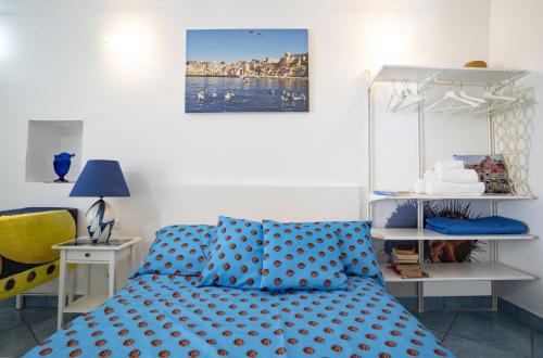 - une chambre dotée d'un lit avec des draps bleus en points de polka dans l'établissement Maridea, à Procida
