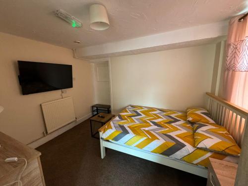 um quarto com uma cama e uma televisão de ecrã plano em One Bedroom Flat with on premises parking em Walsall