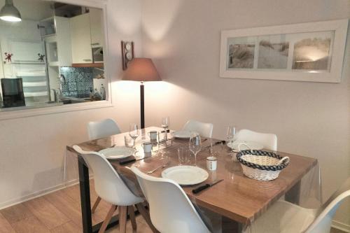 une table à manger avec des chaises blanches, une table en bois et une lampe dans l'établissement Touquet nest near the beach, à Le Touquet-Paris-Plage