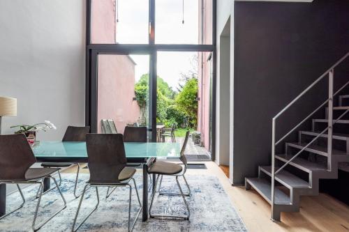 a dining room with a glass table and chairs at Rez/duplex 3 ch et jardin in Brussels