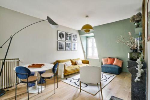 un salon avec un canapé, une table et des chaises dans l'établissement Charming love nest in Paris, à Paris
