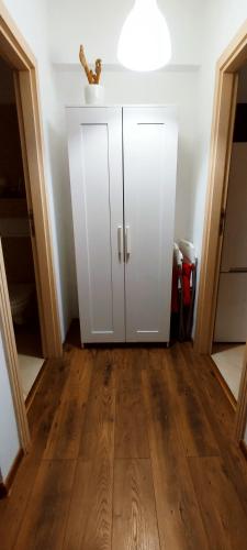 a white cabinet in a room with a wooden floor at STUDIO JACUZZI BELLE VIEW SINAIA-free parking in Sinaia