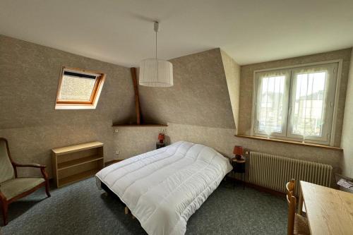 une chambre avec un lit, une chaise et une fenêtre dans l'établissement Norman house facing the sea, à Villerville