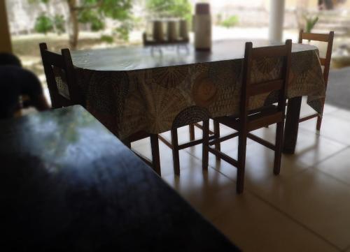 a dining room table with two chairs and a table with at Bitingui Infinity in Japaratinga