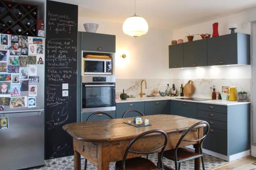 une cuisine avec une table en bois et un réfrigérateur dans l'établissement Spacious cocoon with parking, à Aubervilliers