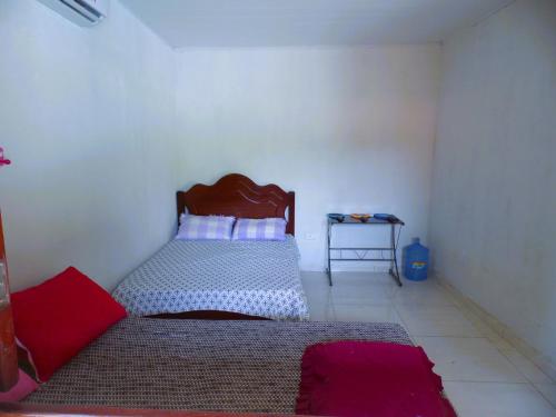 a small bedroom with a bed and a table at Bitingui Infinity in Japaratinga