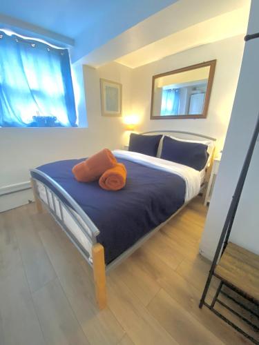 Chapel Court - Worcester City Centre - Free Parking Available - Entire Apartment - Self Check-In - Outside Space - Free WI-FI في وستر: غرفة نوم بها سرير وفوط برتقال عليها