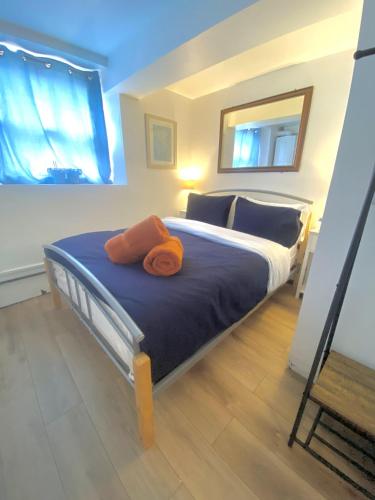 a bedroom with a bed with two orange towels on it at Chapel Court - Worcester City Centre - Free Parking Available - Entire Apartment - Self Check-In - Outside Space - Free WI-FI in Worcester