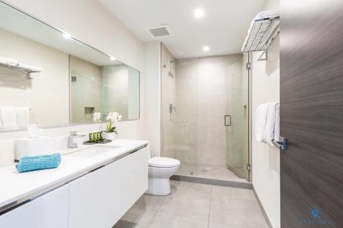 La salle de bains blanche est pourvue d'une douche et de toilettes. dans l'établissement Rooftop Pool- Gym - Hollywood Beach Broad - walk, à Hollywood