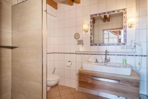 a bathroom with a sink and a toilet and a mirror at Obst- Ferienhof Ragg in Immenstaad am Bodensee