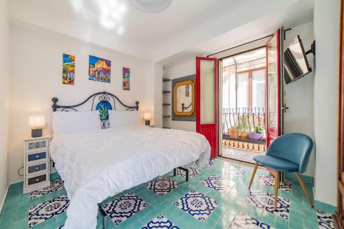 a bedroom with a white bed and a blue chair at Cascabella Taormina in Taormina