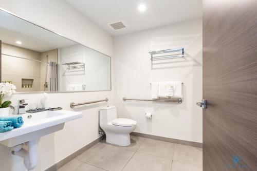 a bathroom with a toilet and a sink and a mirror at NEW!Beachfront Condo Resort- Balcony in Hollywood
