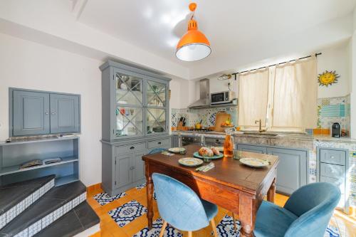 a kitchen with a wooden table and blue chairs at Cascabella Taormina in Taormina