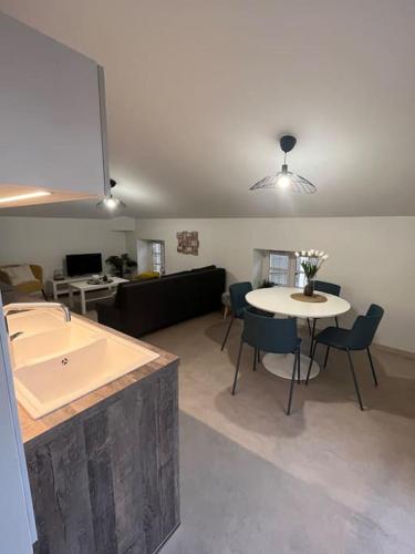 - un salon avec une cuisine et une table avec des chaises dans l'établissement Appartement élégant, 2 chambres et terrasse Rofftop, à Montélimar
