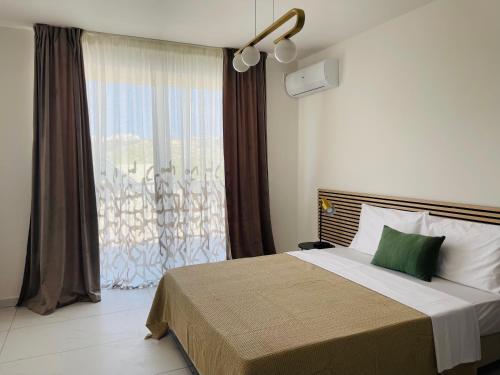 - une chambre avec un lit et une grande fenêtre dans l'établissement Blu Mar Sea View Apartments, à San Pawl il-Baħar