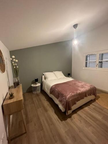 a bedroom with a bed and a wooden floor at Appartement élégant, 2 chambres et terrasse Rofftop in Montélimar