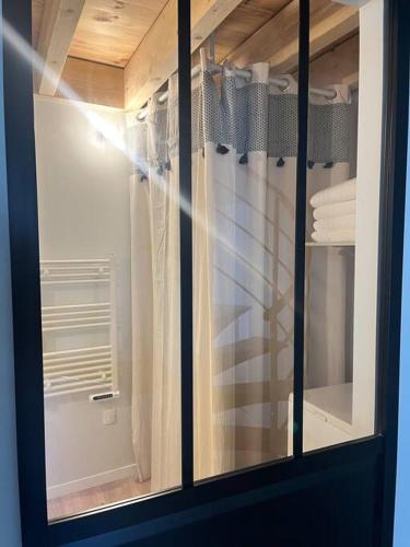 a glass cabinet with a window in a bathroom at Appartement neuf, centre-ville in Argenton-sur-Creuse