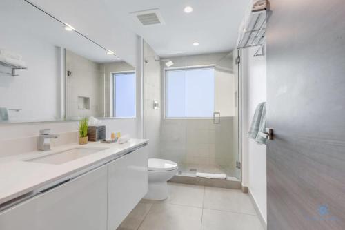 een witte badkamer met een toilet en een douche bij Rooftop Pool - Balcony - Hollywood Beach Broad - walk in Hollywood
