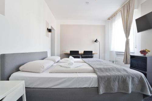a bedroom with a large white bed with two chairs at Stilvolle Apartments in Bonn I home2share in Bonn