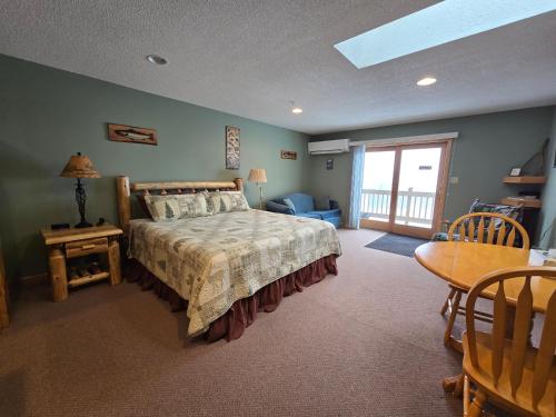 Weston的住宿－First Settlers Lodge，一间卧室配有一张大床、一张桌子和一张桌子。
