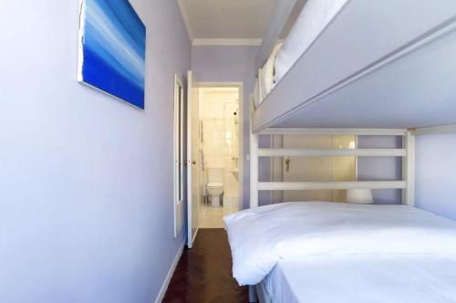 een kleine slaapkamer met een bed en een badkamer bij Spacious Apartment in Belém in Lissabon