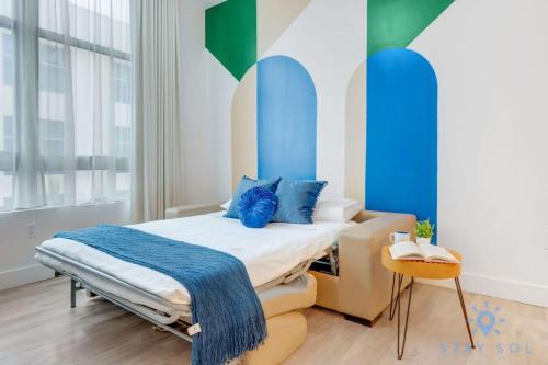 een slaapkamer met een bed met blauwe kussens erop bij Lx Oasis Beachfront-Rt infinity POOL in Hollywood