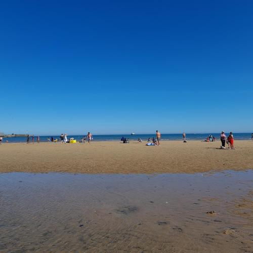a group of people standing on a beach at 247a South Shore Pet friendly in Bridlington