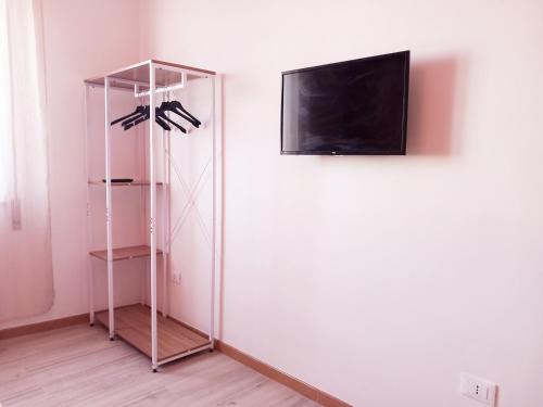 a room with a tv and a shelf with shoes at RoofTop Home Stagnone in Marsala