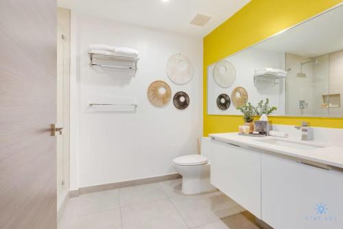 a bathroom with a sink and a toilet and a mirror at Hollywood Beach Broad - walk - Gym - Amazing Pool in Hollywood