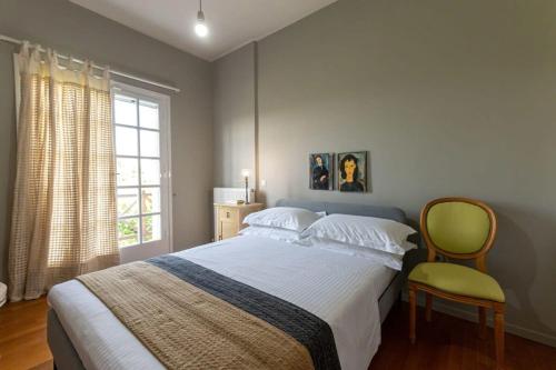 sypialnia z łóżkiem, krzesłem i oknem w obiekcie Serene Seaside Bliss - Lush & Secluded Garden Oasis w Kalamácie