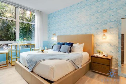 a bedroom with a large bed with blue wallpaper at Best Stay - Rooftop Pool & Hot Tub - Hollywood Beach in Hollywood